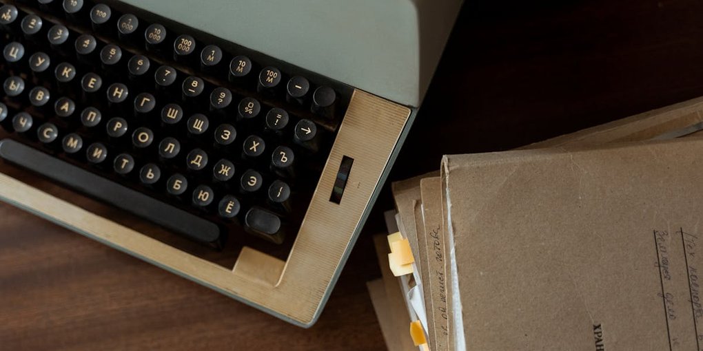 Vintage typewriter beside stacked archival documents — the Chocolate Shells archive